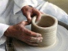 Potter forming a jar from clay on a wheel