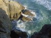 Photo looking down from mountain to sea cove, rocks, water, waves