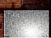 Silver shiny rough textured block against dark brick background