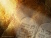 Full screen image of ten commandments lit by beam of light, law, stone