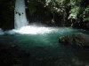 Dark photo of bottom of waterfall in Israel entering a calm pond, living water