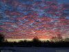 Photo of sunset with red and blue clouds over horizon