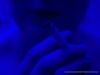 close up photo of person with cigarette, all dark blue, low contrast