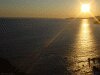 Dark toned photo of sunset on Pacific Ocean horizon.