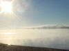 Photo of bridge over Mississippi mostly, of sky and water, with sun in upper corner