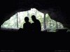 Color silhouetted photo of two people at mouth of cave, light, darkness, hope