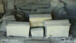 Color photo of ossuaries, stone boxes used to hold bones of ancestors removed from tombs.