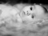Full screen, grayscale photo of a baby lying in straw, jesus, moses