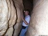 Color photo of man squeezed between rocks, cave, pressure, hard place, camel