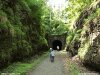 Color photo of road through tunnel, rocks, trials, darkness
